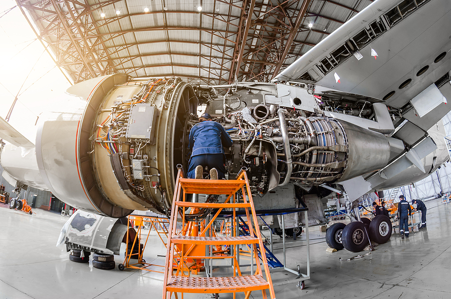 How an Aerospace Contract Manufacturer Ensures Safety Standards - Specialist mechanic repairs the maintenance of a large engine of a passenger aircraft in a hangar
